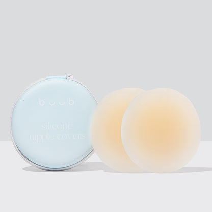A pair of large 10cm Buub non-adhesive silicone nipple covers in nude for maximum coverage. The reusable pasties are shown with their cream-coloured storage case.