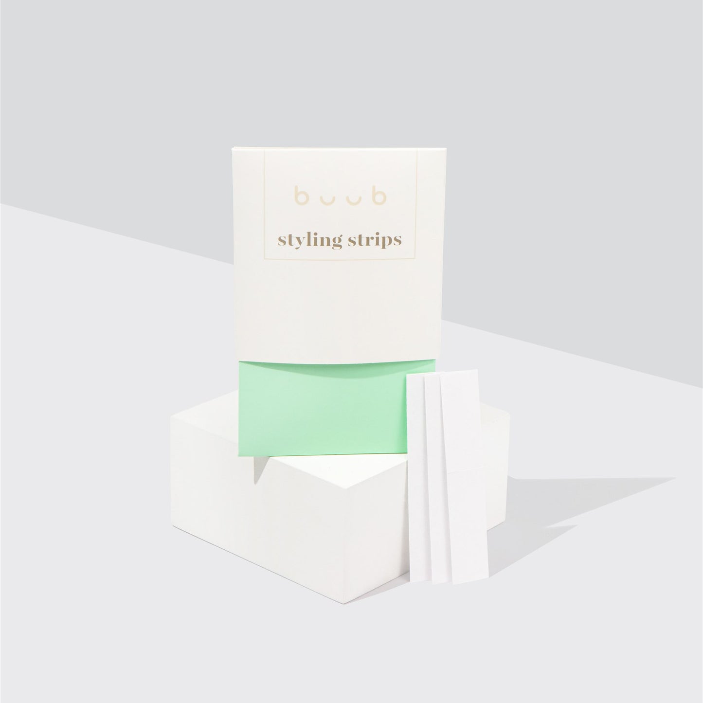 Buub Styling Strips, a double-sided fashion tape for securing clothing. The minimalist white and mint green packaging is displayed on a white block with several individual strips shown.